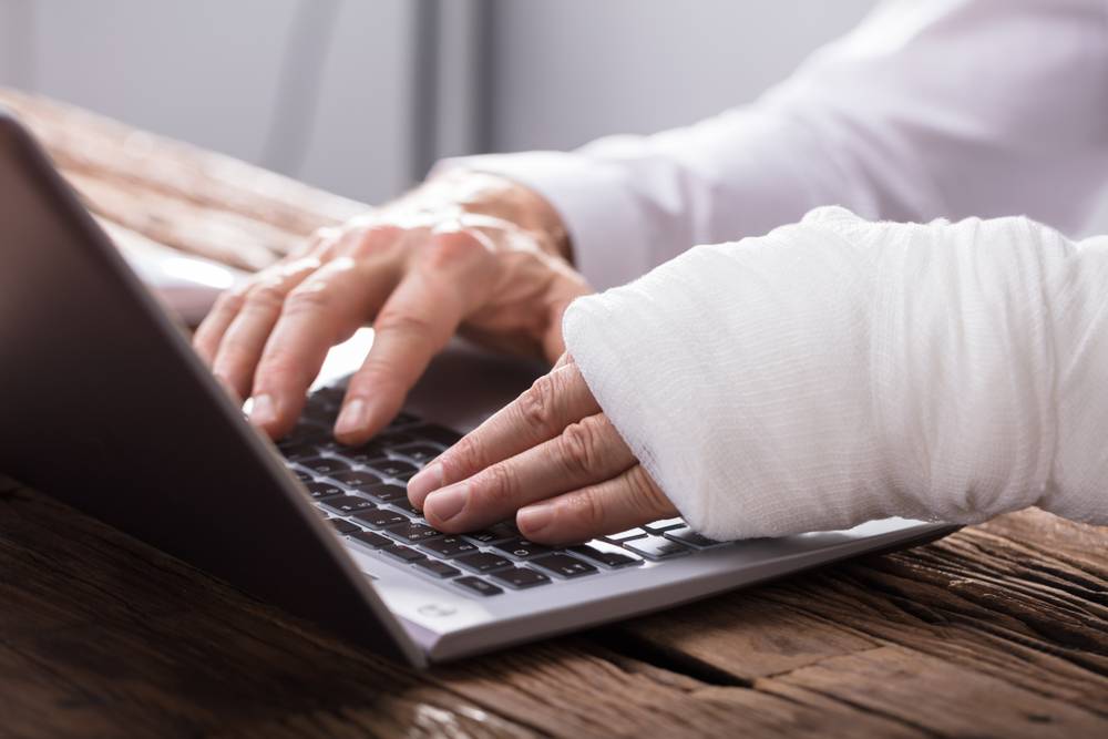Hand Injured Person Using Laptop